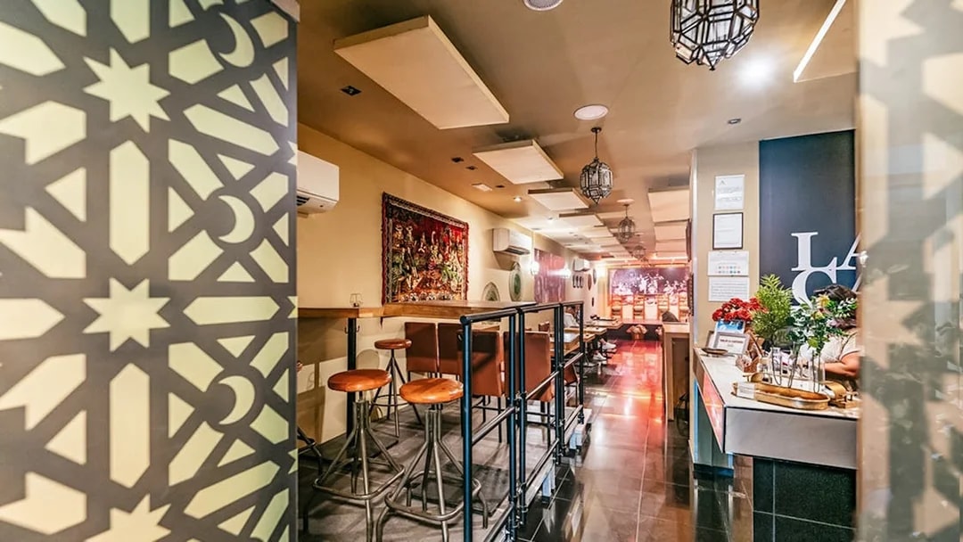 Flamenco show venue interior with bar seating and decorative wall panel.