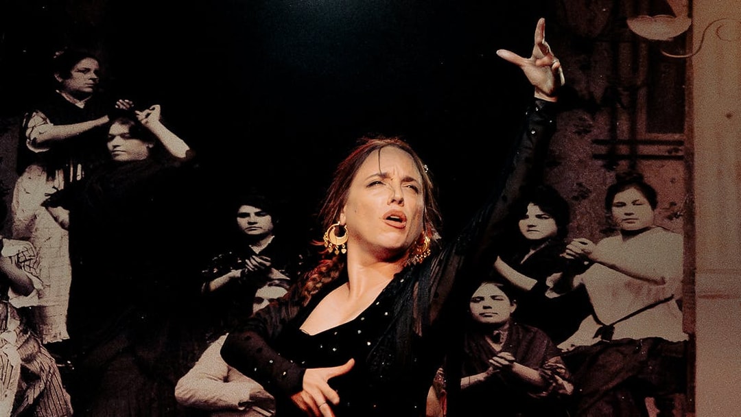Flamenco dancer performing at Tablao La Cantaora with musicians in the background.