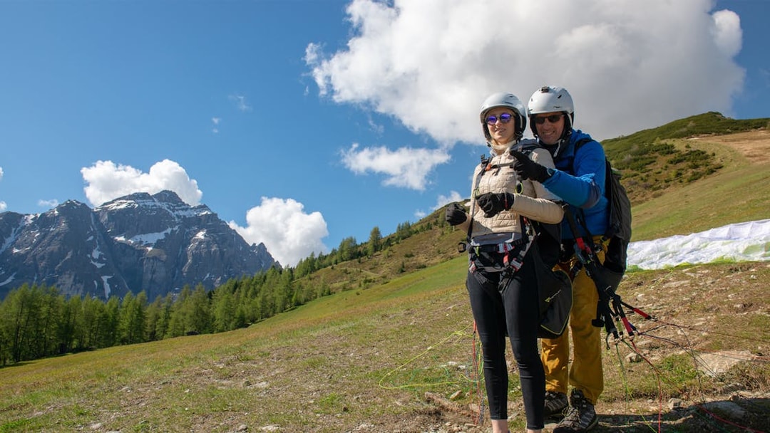 Tandem paragliding preparation in Tirol with scenic mountain backdrop.