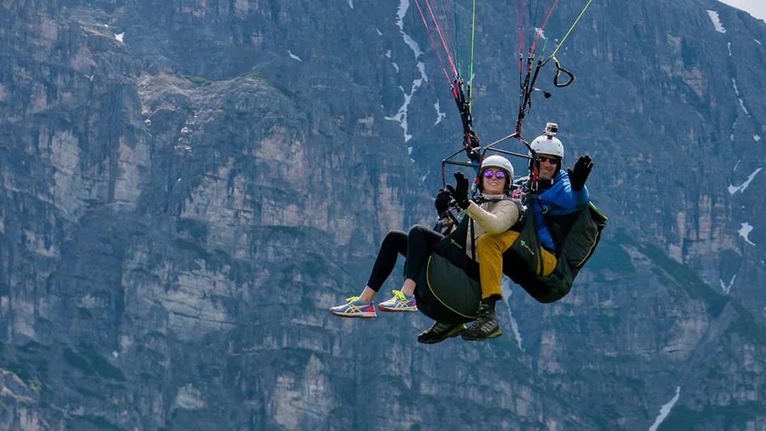 Tandem paragliding over mountainous landscape in Tirol.