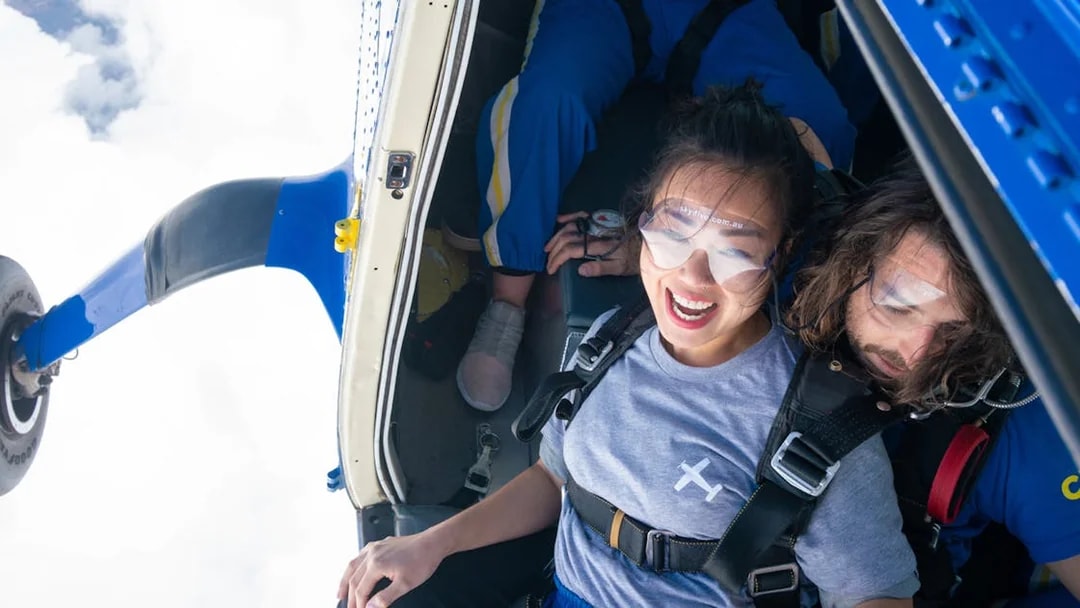 Tandem skydivers preparing to jump from a plane over Great Ocean Road.