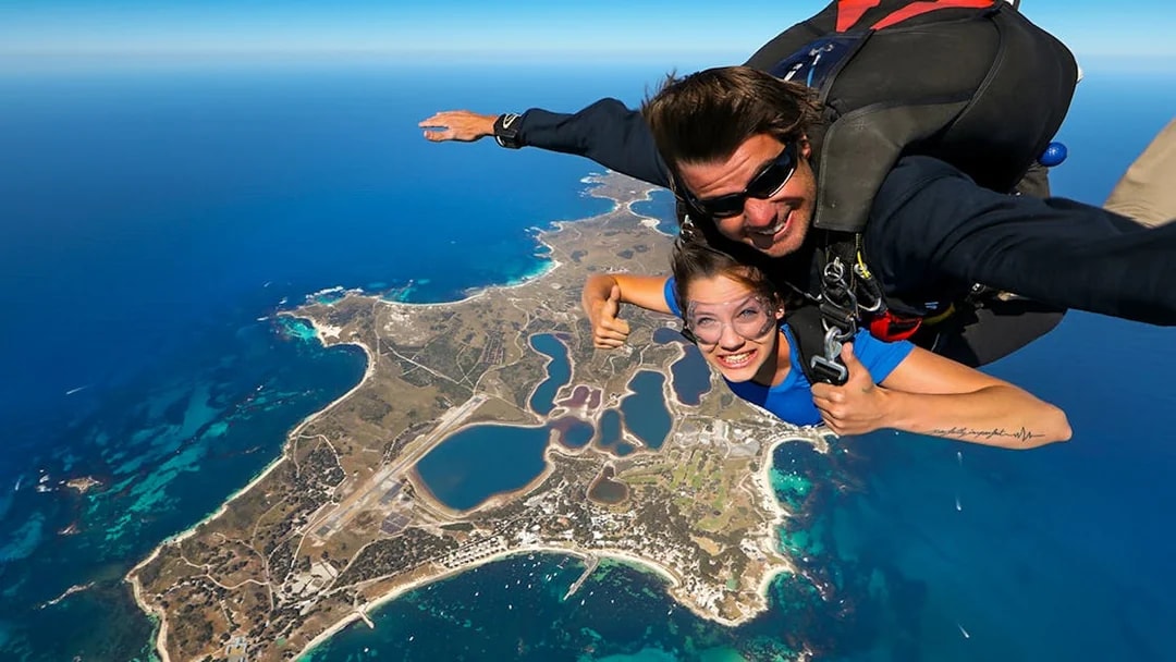 Tandem skydive over Rottnest Island, Perth, with aerial view of coastline and landscape below.