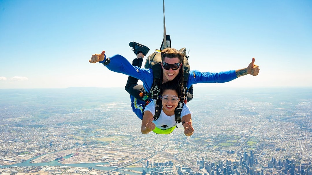 Tandem skydive over Melbourne with view of St Kilda Beach and cityscape below.