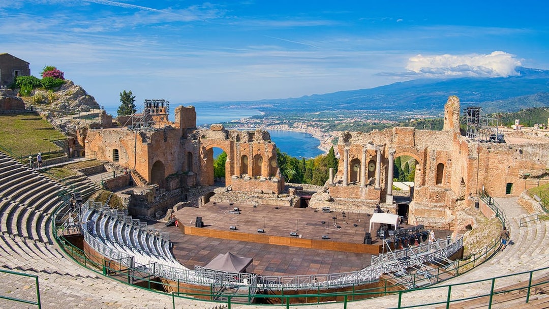 Panoramic view of ancient theatre of Taormina with coastline in background, Sicily.