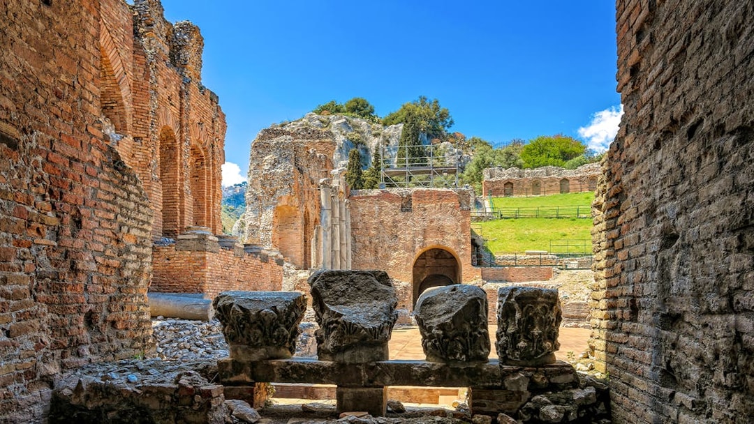 Taormina Ancient Theatre ruins with stone columns and archways, Sicily.