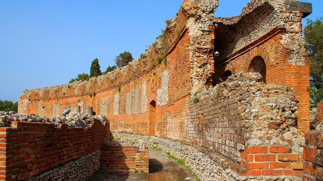 Taormina Ancient Theatre ruins with stone arches and brick walls, Sicily.