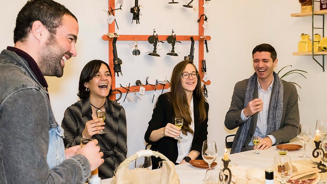 Group enjoying tapas and drinks at a table in Seville during a tasting tour.