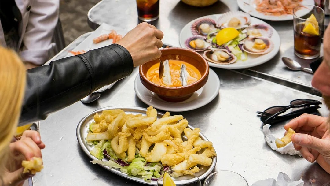 Participants enjoying seafood dishes on a Tapas Tasting Tour in Seville.