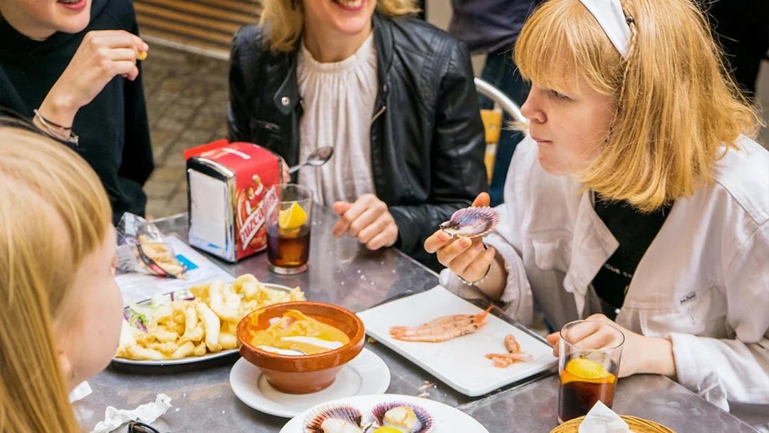 Tapas tasting tour in Seville with people enjoying seafood and drinks at a table.
