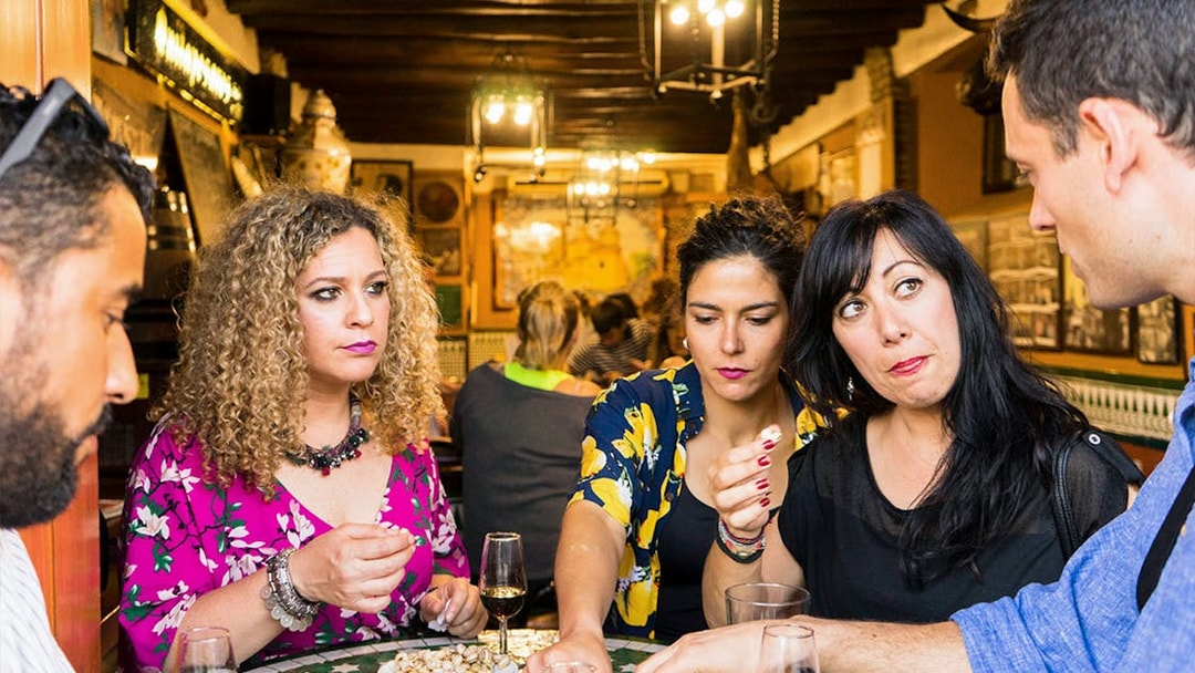 Group enjoying tapas and drinks at a traditional bar in Seville during a tasting tour.