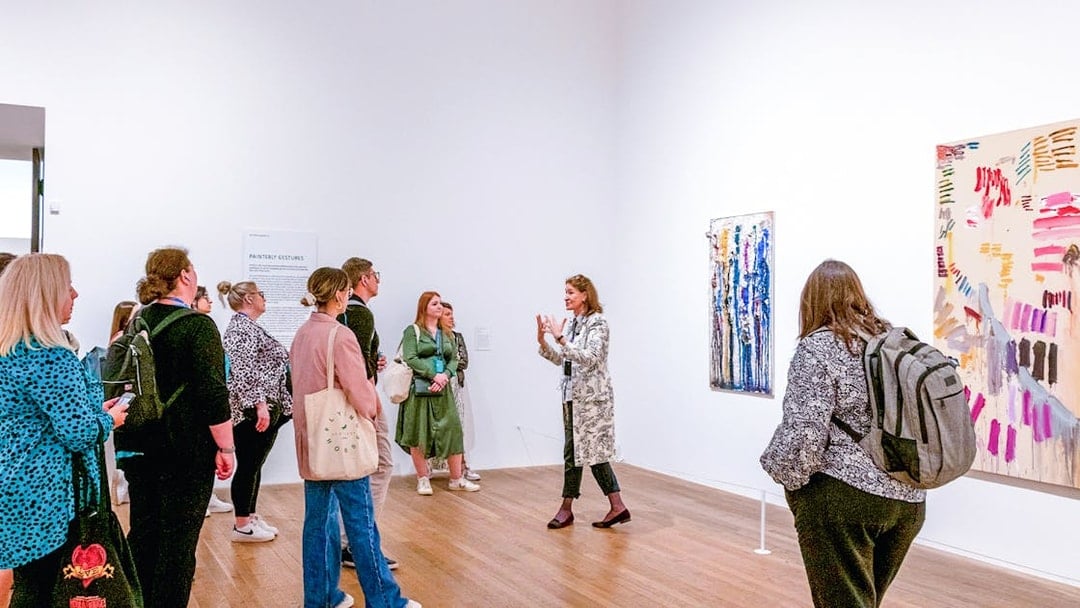 Group listening to a guide inside Tate Modern gallery.