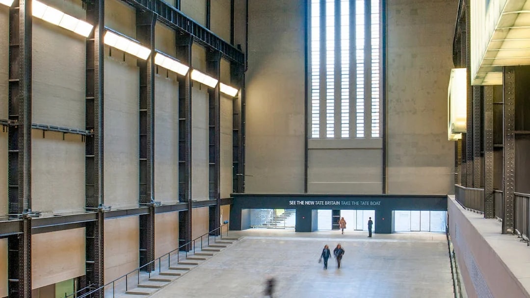 Tate Modern Turbine Hall interior with visitors walking through the large open space.