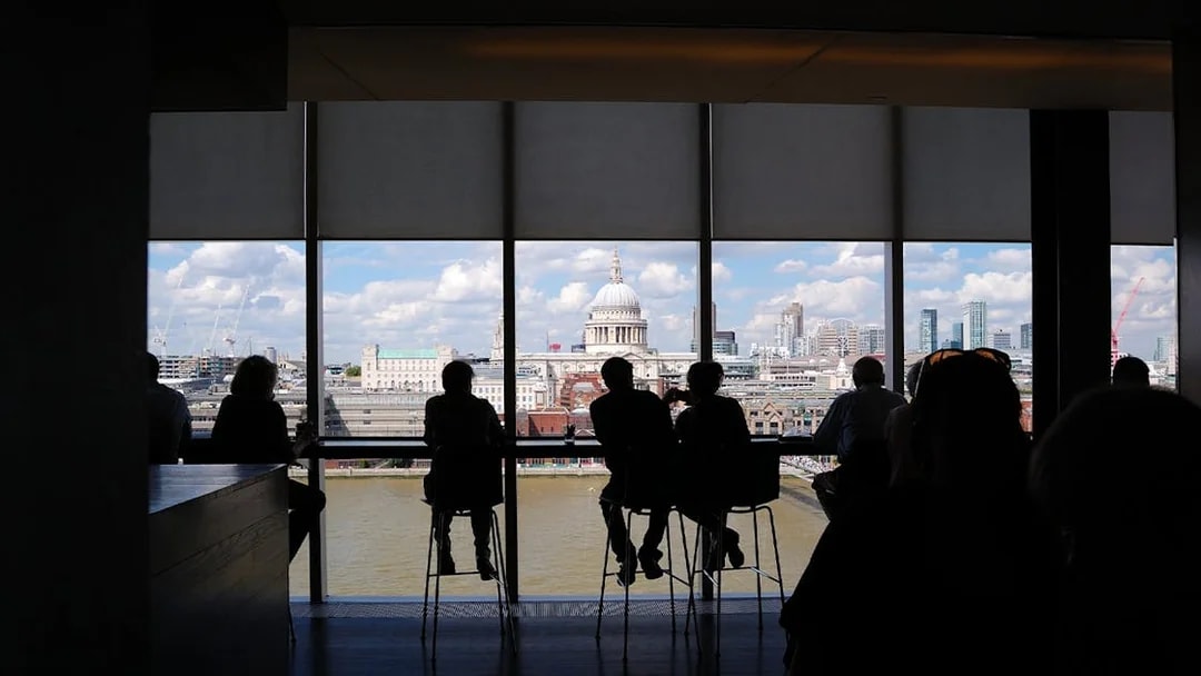 People enjoying the London skyline view from Tate Modern, featuring St. Paul's Cathedral.