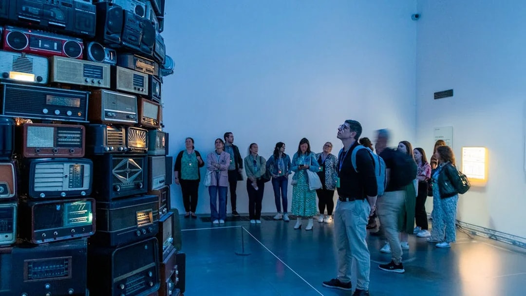 Visitors observing vintage radio installation at Tate Modern, London.
