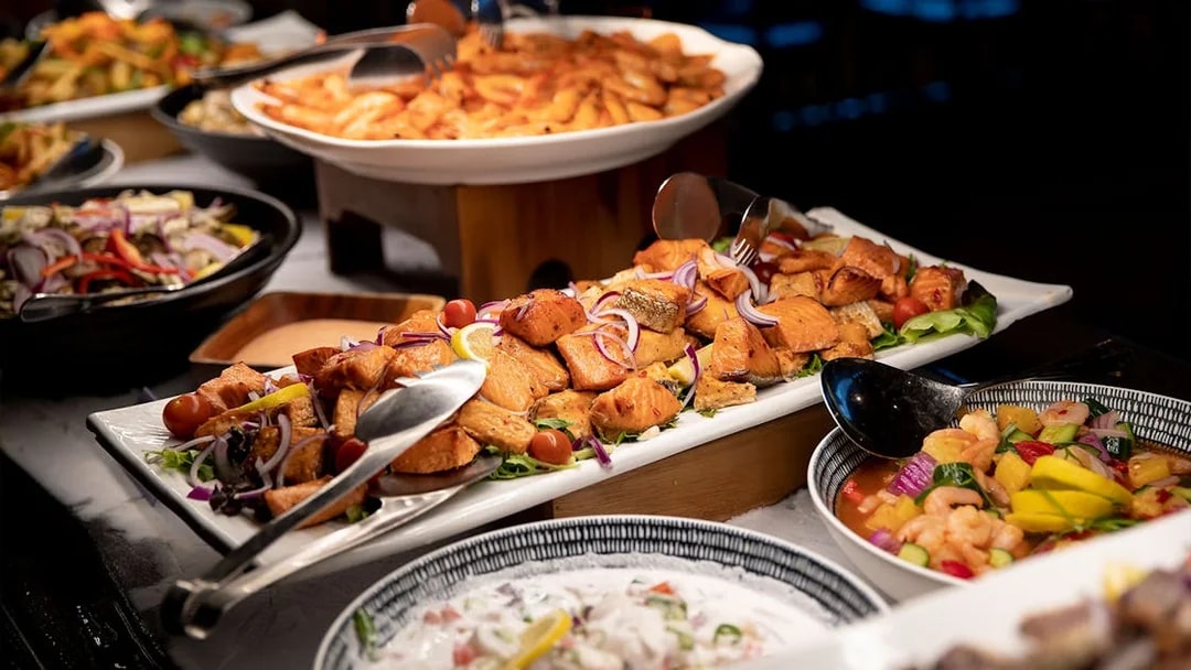 Te Puia buffet with salmon, vegetables, and traditional dishes in Rotorua, New Zealand.
