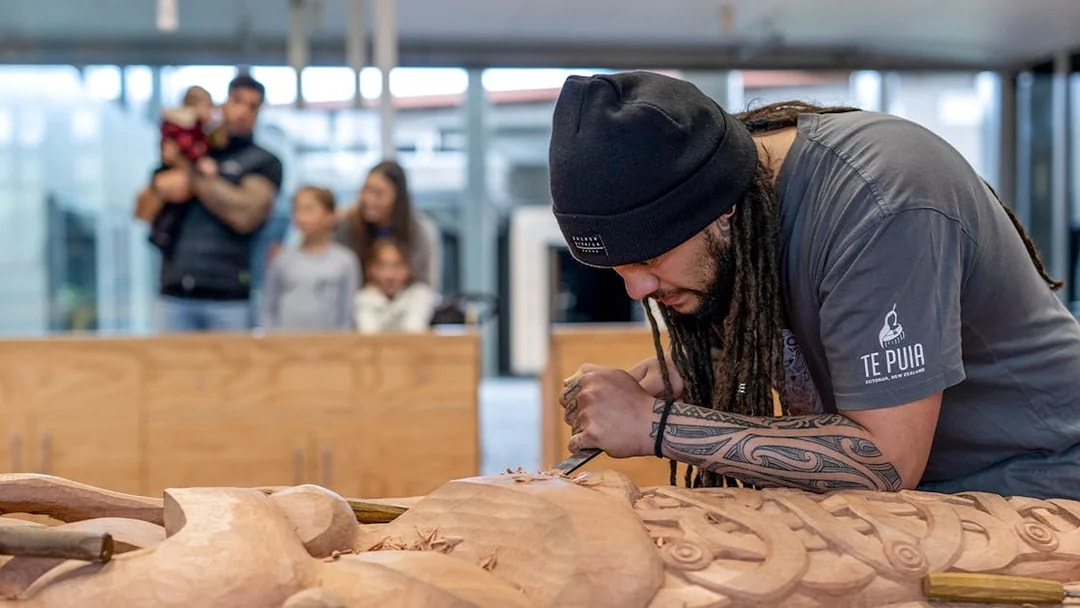 Carver working on Māori wood sculpture at Te Puia, Rotorua, New Zealand.