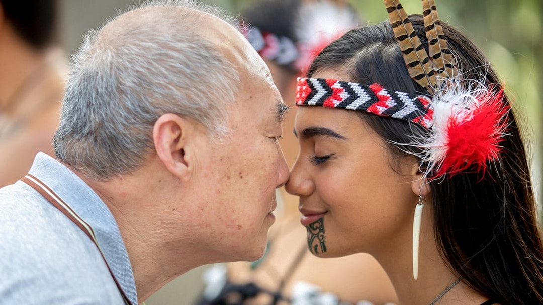 Man and woman sharing a hongi at Te Puia, New Zealand, during Te Rā Guided Experience.