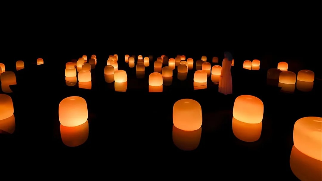 Glowing orange lanterns in a dark room at TeamLab Phenomena Abu Dhabi.