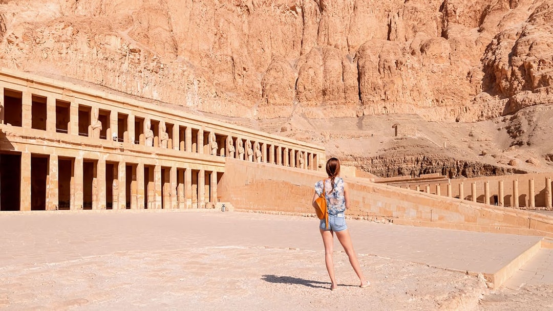 Tourist admiring Hatshepsut Temple's ancient architecture in Luxor, Egypt.