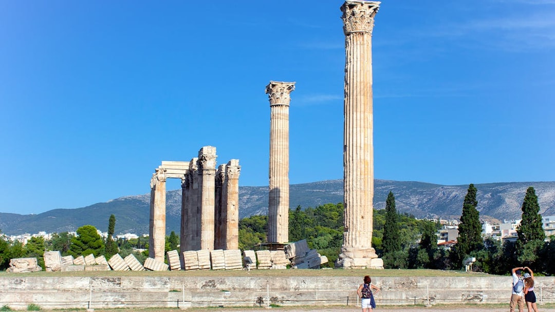 Temple of Olympian Zeus ruins with tourists in Athens, Greece.