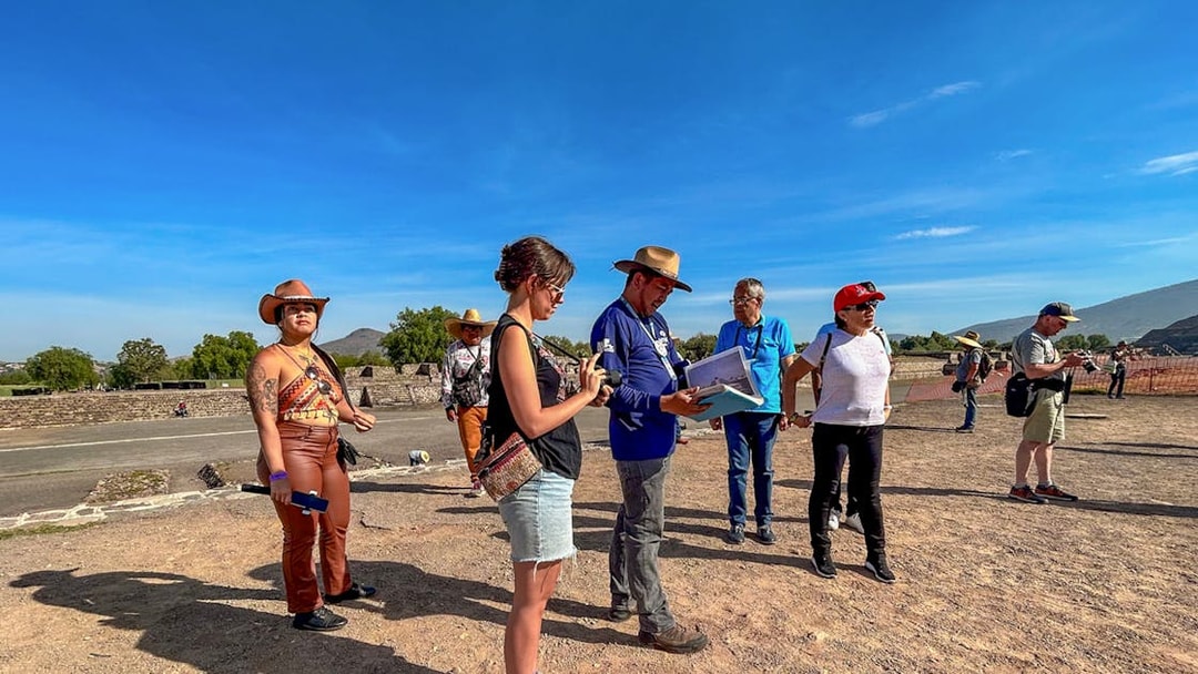 Tour group exploring Teotihuacan, Mexico with a guide explaining the site.