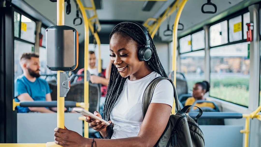 Person using phone on London bus transfer.