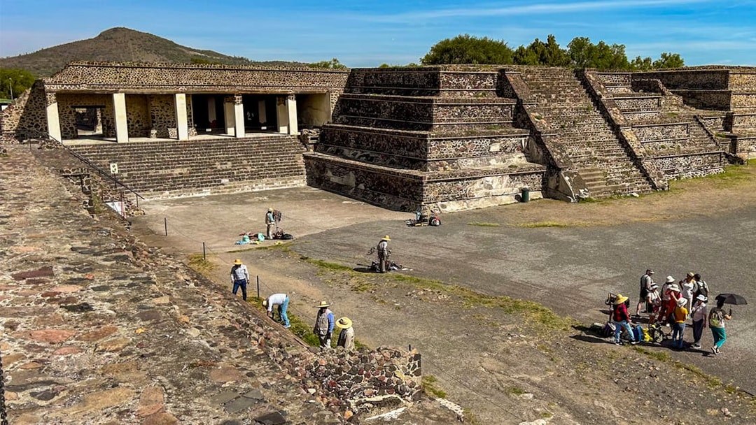 Entrance to the Palace of Quetzalpapalotl with tourists exploring the ancient site.