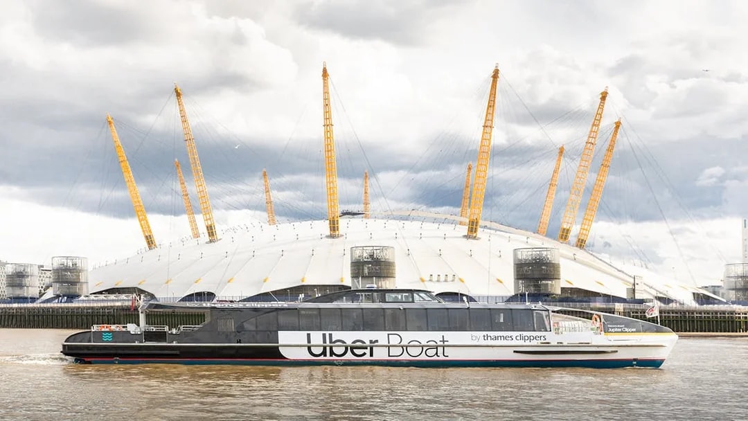 Uber Boat by Thames Clippers passing the O2 Arena on the Thames River.