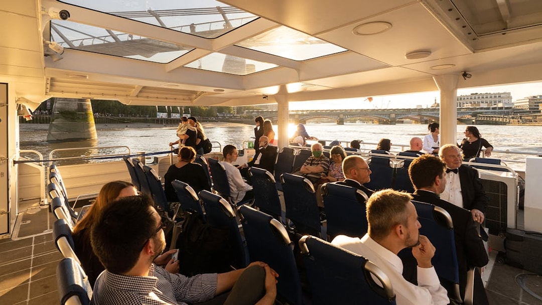 Passengers enjoying a ride on the Thames River Uber Boat with views of London bridges.