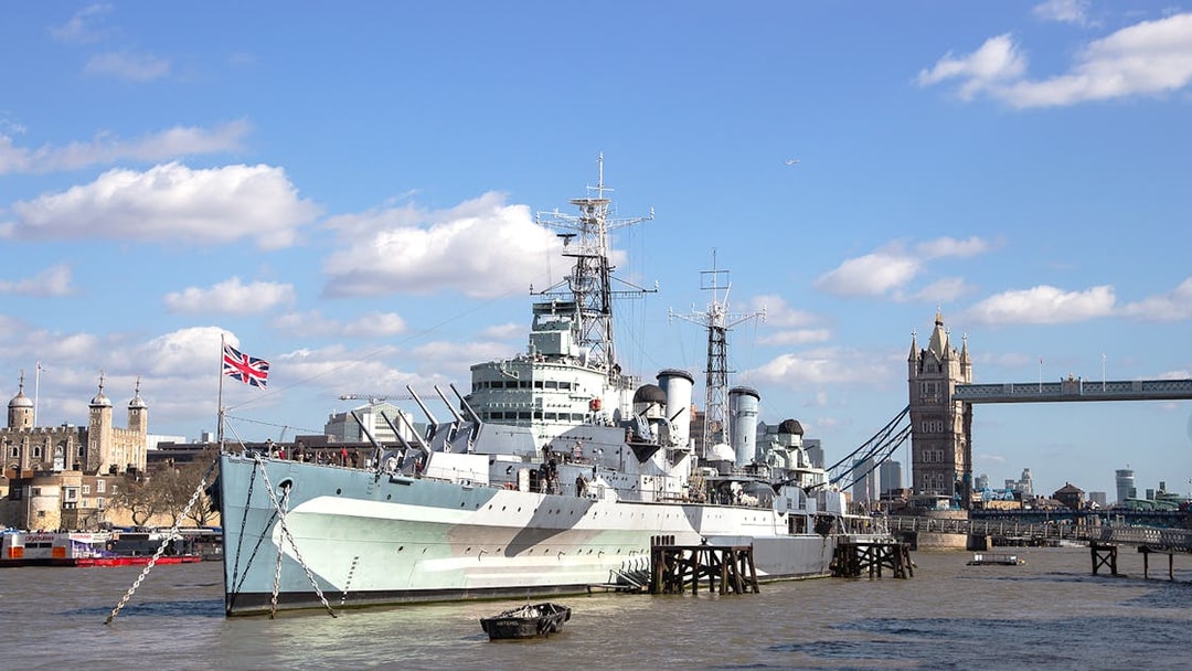 HMS Belfast moored on the River Thames with Tower Bridge in the background, London.
