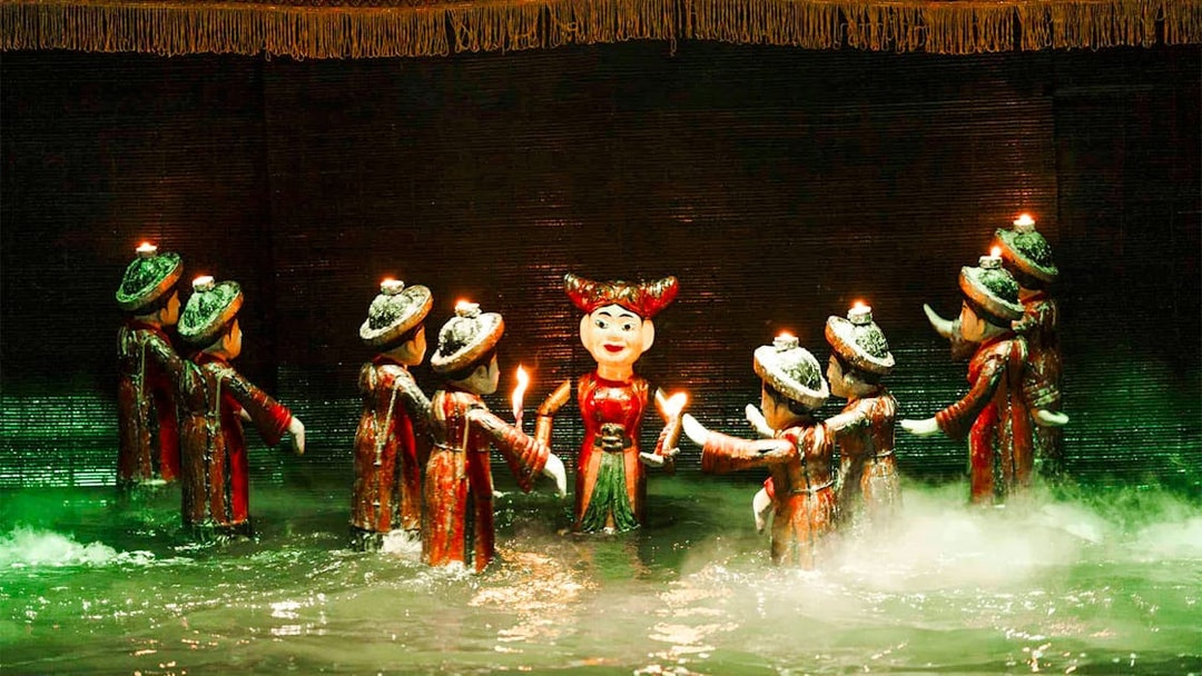 Water puppets holding candles on a misty stage at Thang Long Water Puppet Theatre.