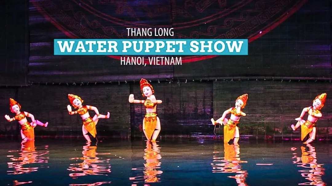 Five puppets in golden costumes performing at Thang Long Water Puppet Show, Hanoi.