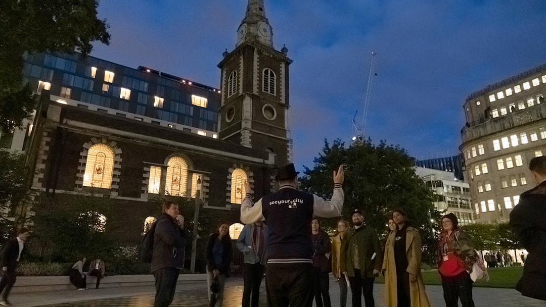 Tour guide leading a group near a historic church on the Jack the Ripper Tour in London.