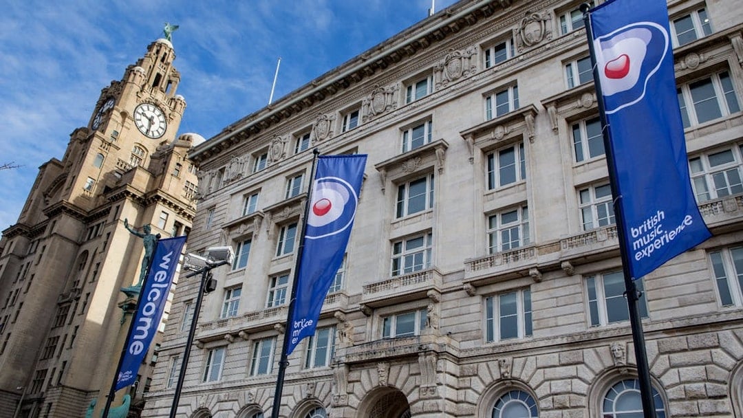 British Music Experience flags outside historic building in Liverpool.