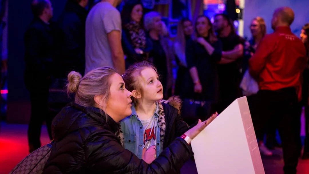 Visitors engaging with an exhibit at the British Music Experience.