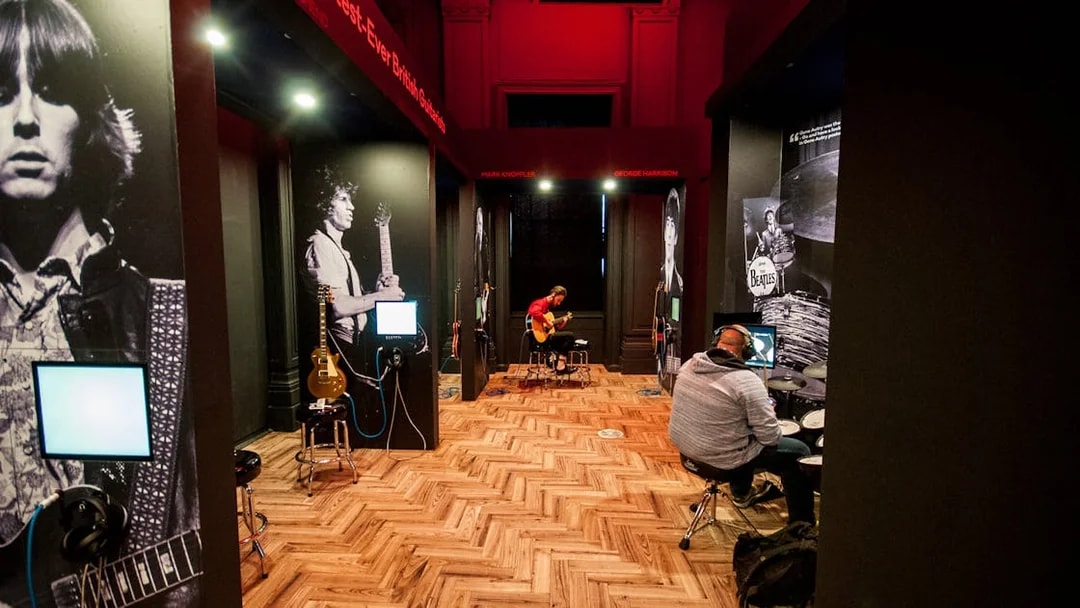 Interactive music exhibit at the British Music Experience with guitars and drum kits.