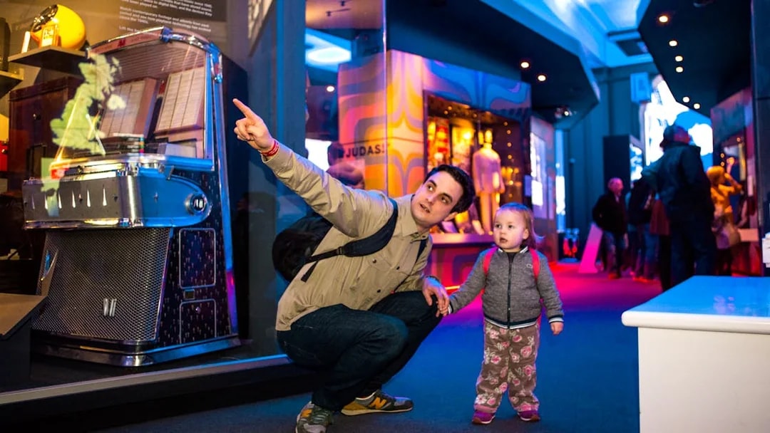 Man and child exploring exhibits at the British Music Experience in London.