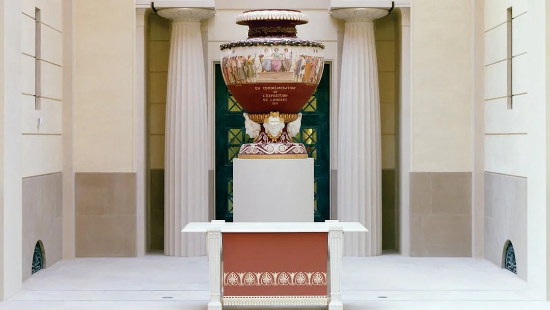 Decorative urn in Buckingham Palace with classical columns in the background.