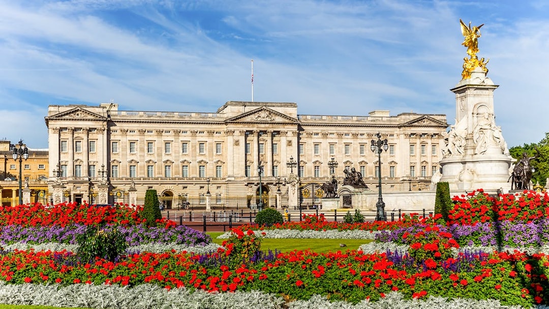 Buckingham Palace with vibrant flower gardens and Victoria Memorial in London.