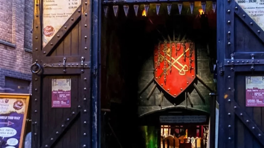 Entrance to The Clink Prison Museum in London with medieval decor and signage.