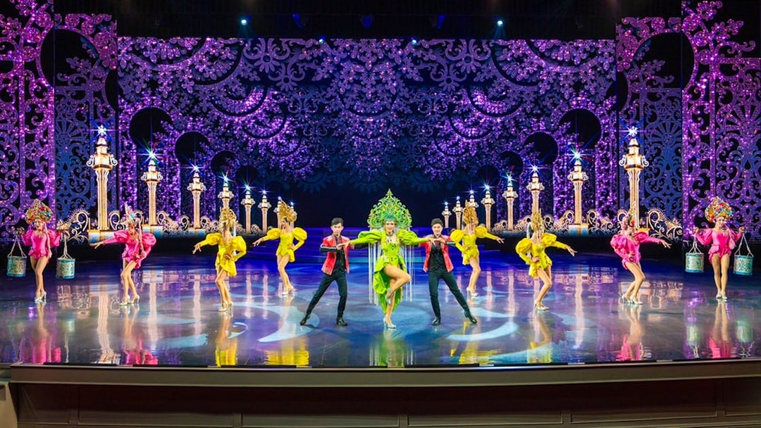 Performers in colorful costumes on stage at The Colosseum Show.