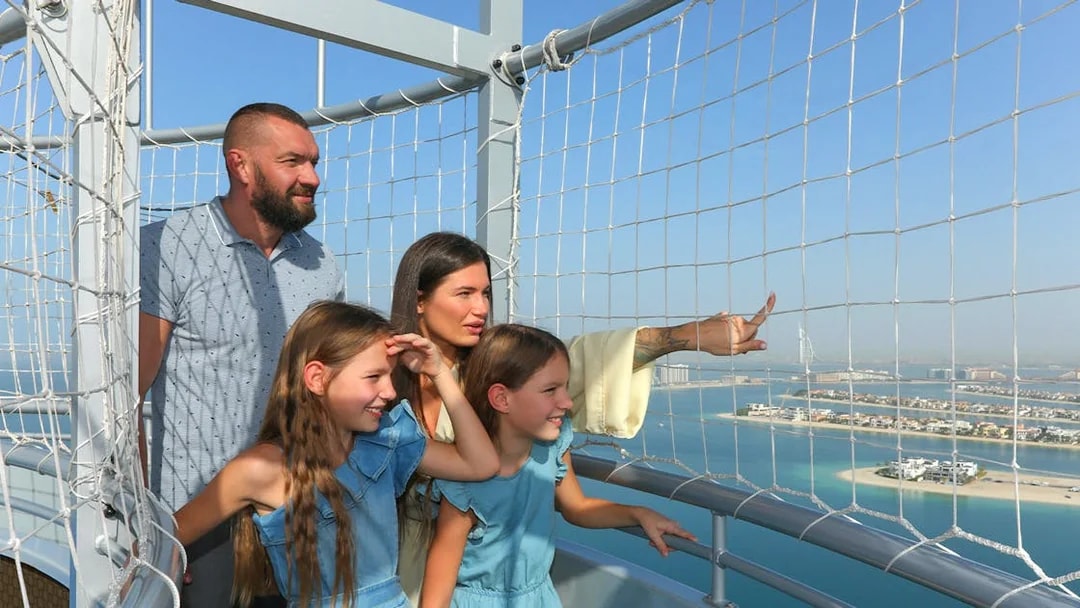 Family enjoying the view from The Dubai Balloon at Atlantis, overlooking the city skyline.