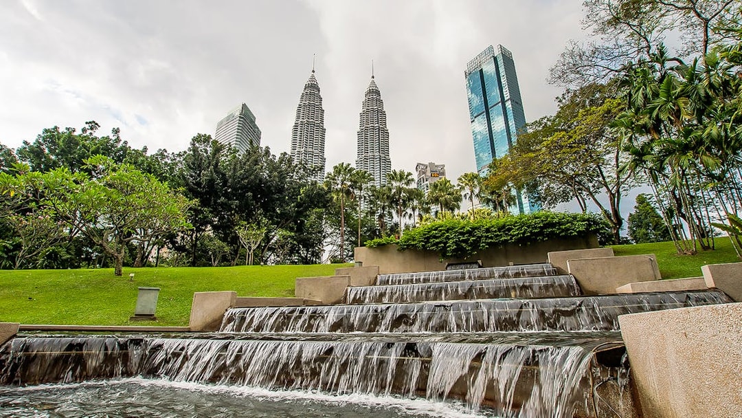 Petronas Towers and KLCC Park waterfall in Kuala Lumpur, Malaysia.