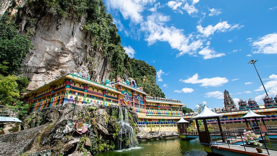Batu Caves temple complex with colorful facade and surrounding limestone cliffs in Kuala Lumpur.