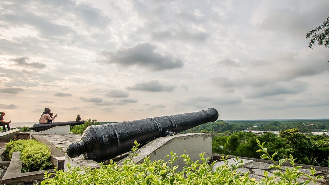 Historic cannon overlooking Kuala Lumpur skyline on Great KL City Tour.