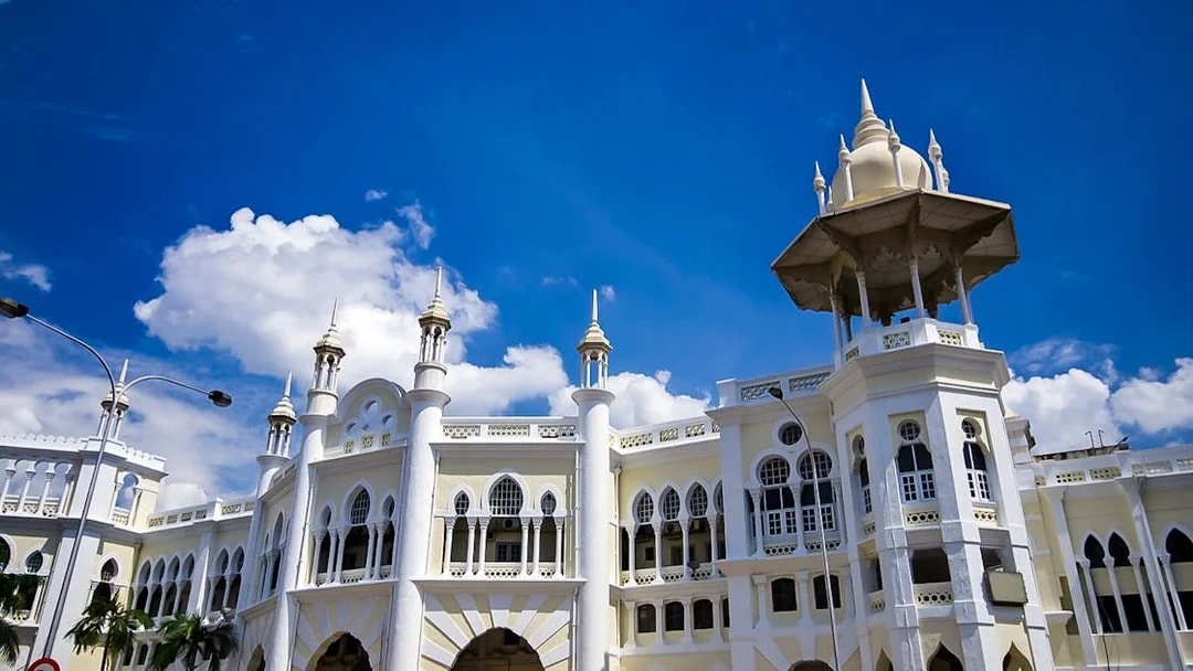 Kuala Lumpur Railway Station with Moorish architecture under a blue sky.
