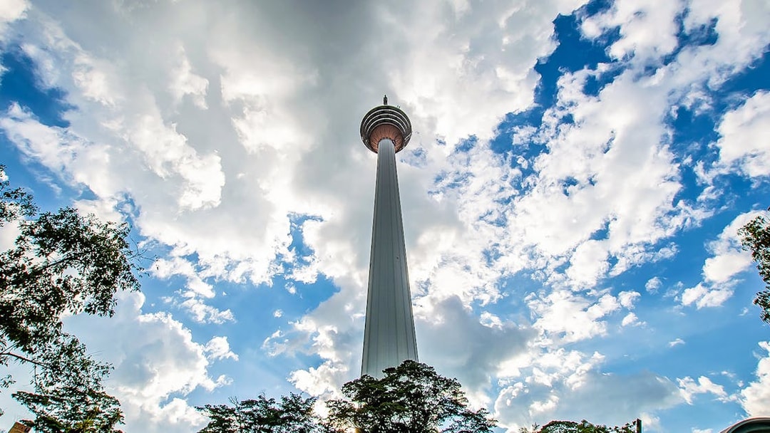 Kuala Lumpur Tower against a cloudy sky, part of the Great KL City Tour.