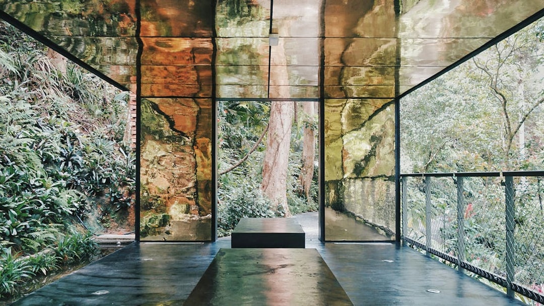 Viewing platform with reflective walls surrounded by lush greenery at Habitat Penang Hill.