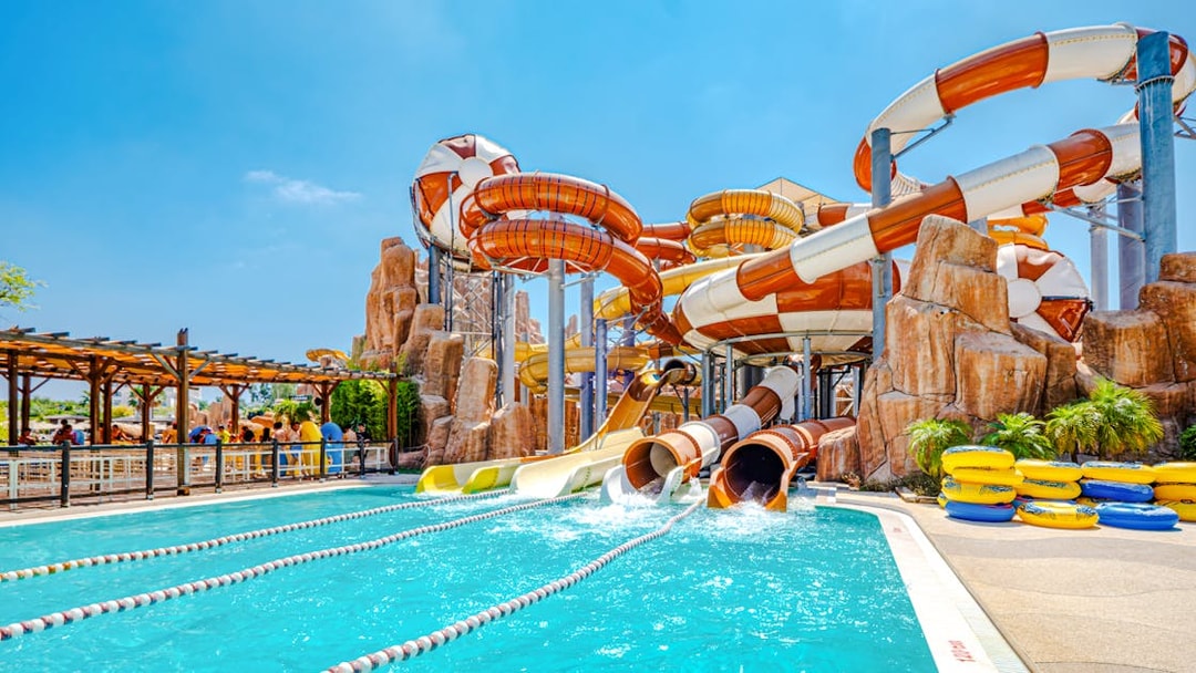 Water slides at The Land of Legends theme park with a pool and colorful tubes.