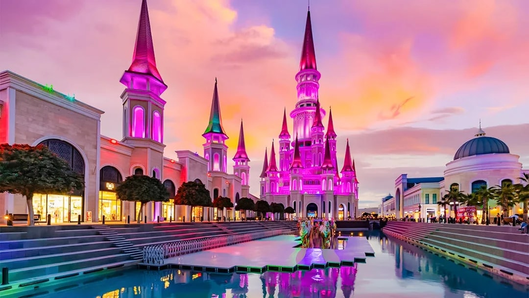 The Land of Legends theme park illuminated at sunset with vibrant colors.